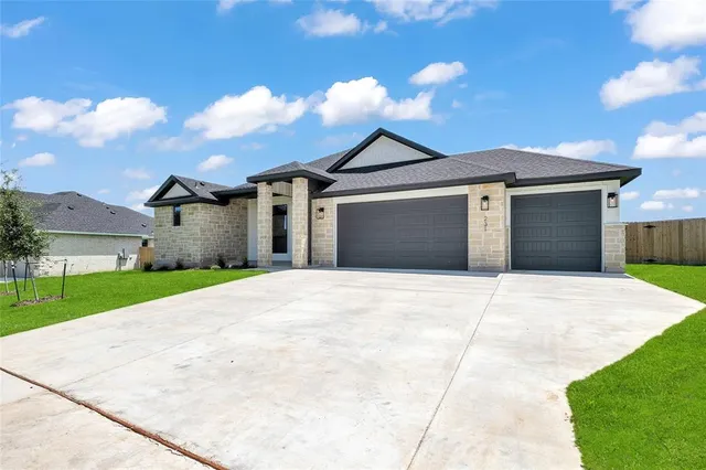 a front view of a house with a yard and garage