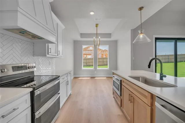 a kitchen with kitchen island granite countertop a sink cabinets and wooden floor