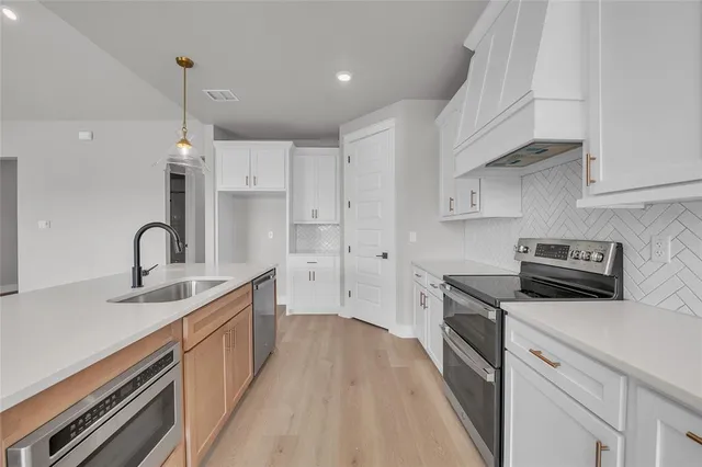 a view of a kitchen counter space a sink stainless steel appliances and cabinets