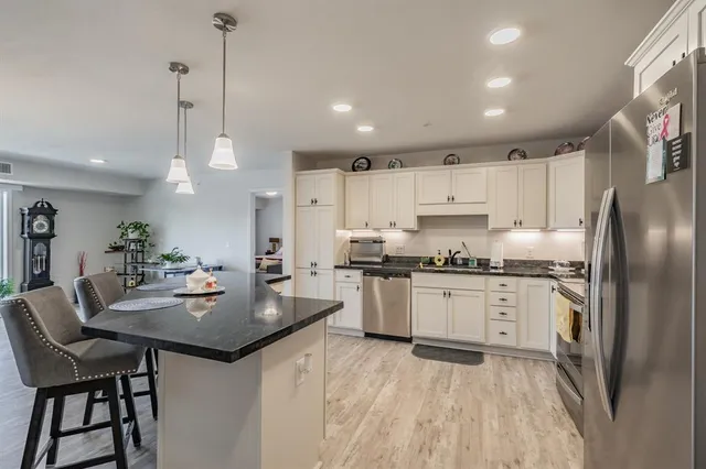 a kitchen with kitchen island a table and chairs in it