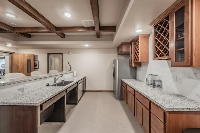 a kitchen with stainless steel appliances granite countertop a sink and a refrigerator