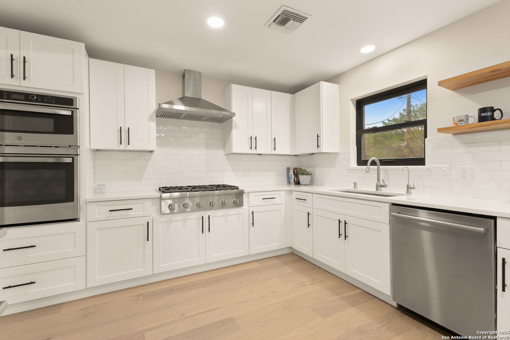 835 Fredericksburg Road New Braunfels, TX 78130 - Photo 20 of 56 a kitchen with granite countertop white cabinets and white appliances