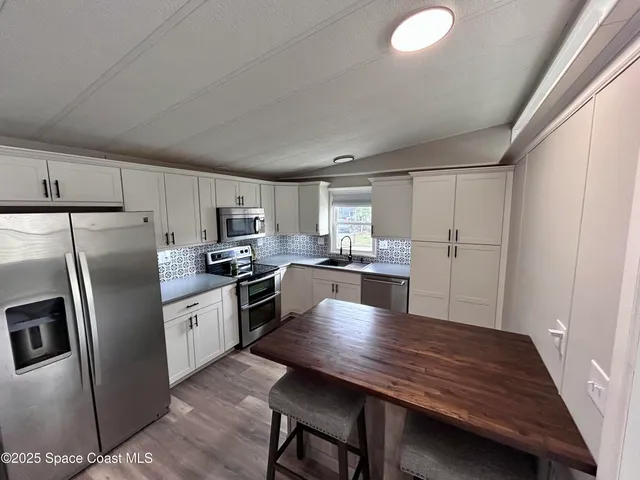 a kitchen with refrigerator cabinets and wooden floor