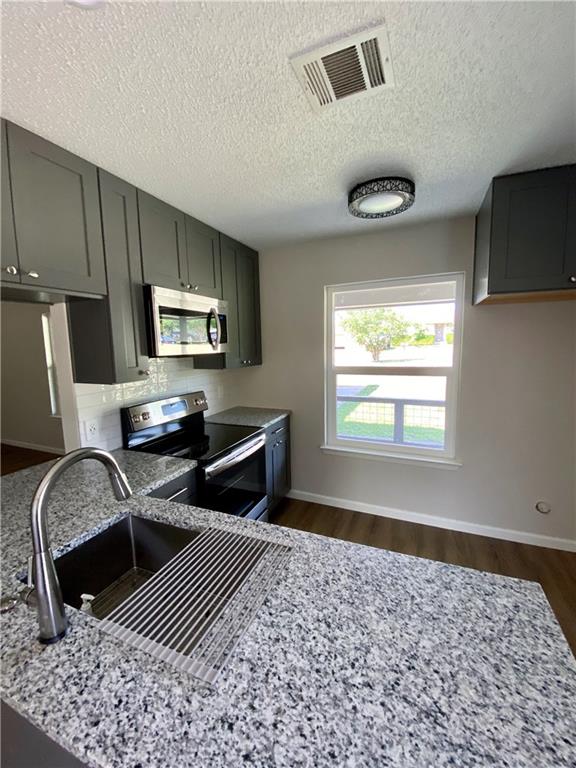 1715 Shadowview Drive, Unit B Austin, TX 78758 - Photo 15 of 28 Modern kitchen with sleek cabinetry, generous counter space, and integrated stainless steel appliances.
