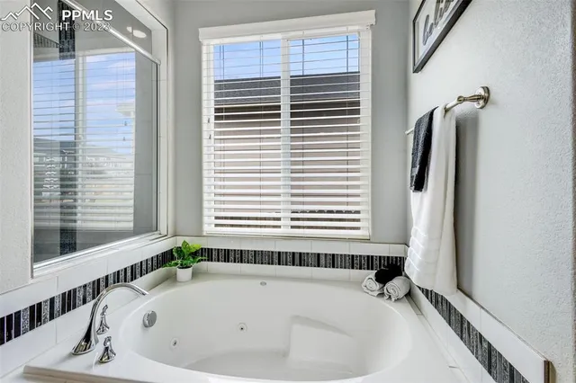 a bathroom with a bathtub next to a window