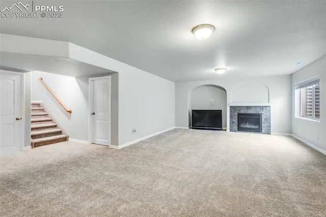an empty room with a fireplace and window