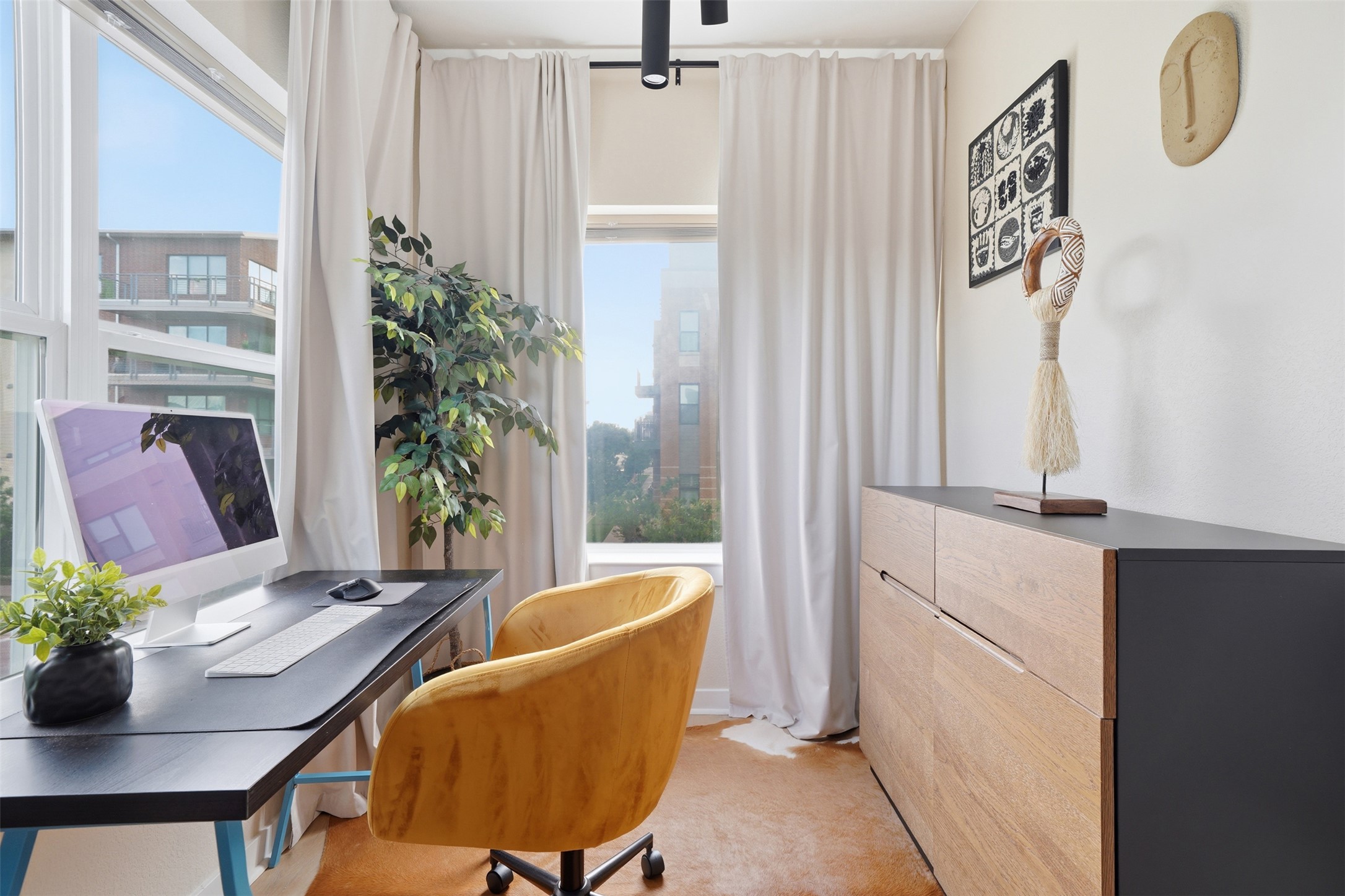 3901 Vaughan Street Austin, TX 78723 - Photo 28 of 37 Dedicated office space featuring expansive windows, wood-finish flooring, a contemporary built-in storage unit with wood-finish drawers and a dark countertop, and track lighting