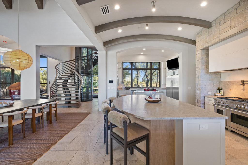 3550 Bell Springs Road Dripping Springs, TX 78620 - Photo 13 of 40 Kitchen featuring light stone countertops, premium appliances, a kitchen breakfast bar, a center island, and a barrel ceiling