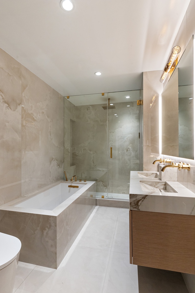 21 West 17th Street, Unit 5 Manhattan, NY 10011 - Photo 14 of 18 a bathroom with a bathtub a sink a toilet and a mirror