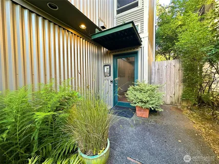 a potted plant sitting in front of a house with a garden