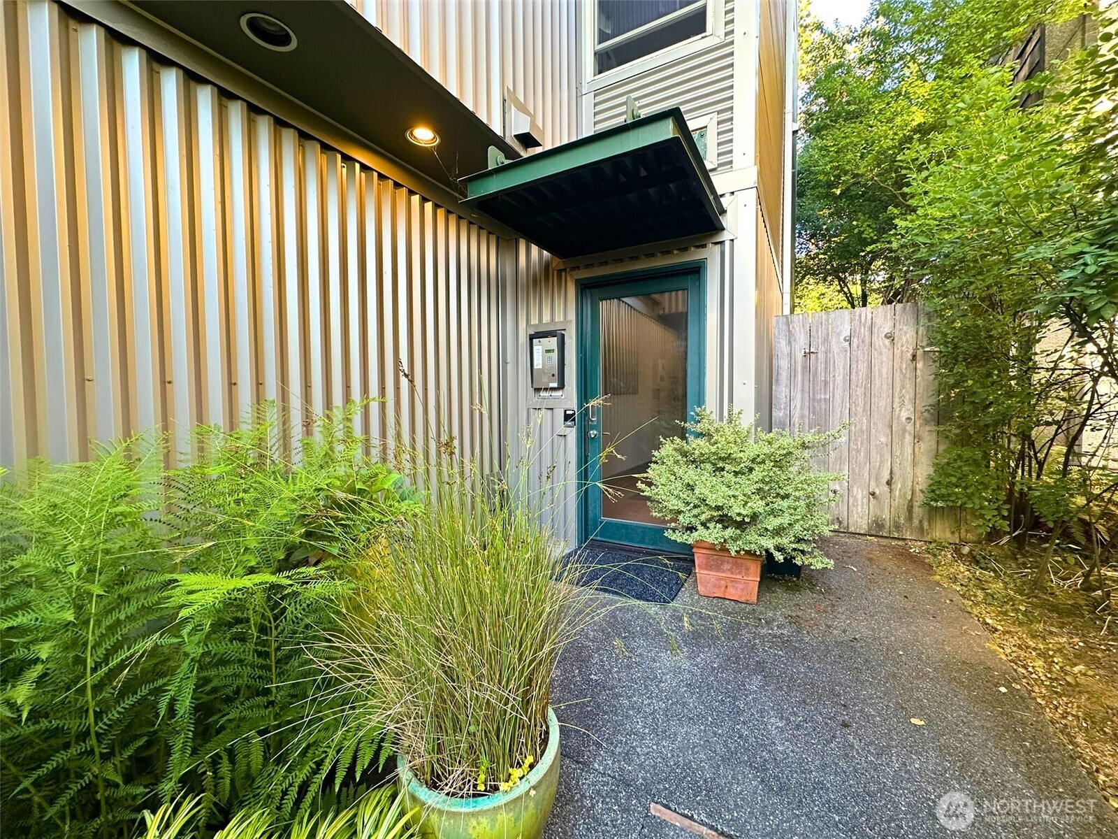 3204 Alki Avenue Southwest, Unit 1 Seattle, WA 98116 - Photo 5 of 35 a potted plant sitting in front of a house with a garden