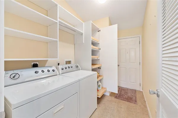 a view of washer and dryer with kitchen in the background