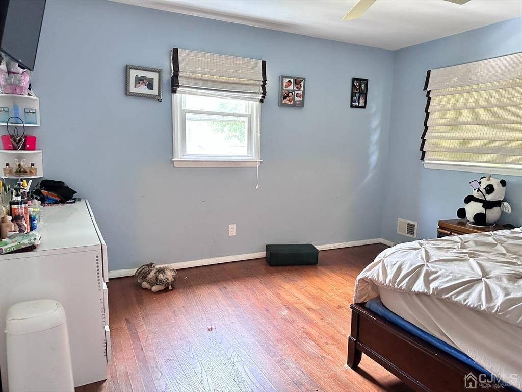 1722 Holly Road North Brunswick, NJ 08902 - Photo 7 of 22 a bedroom with a bed and wooden floor