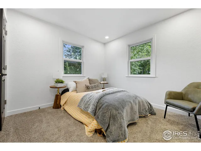 a bed room with two bed and a chair