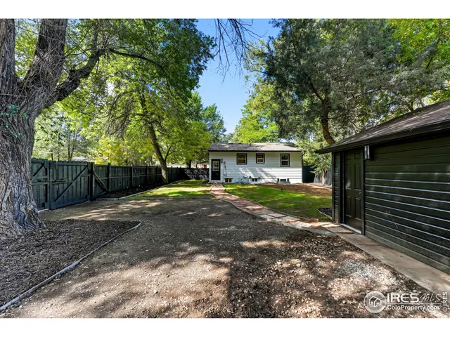 a view of a house with backyard and a tree