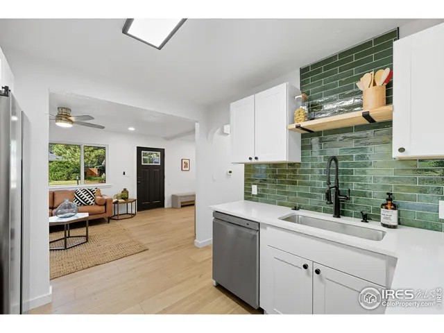 a kitchen that has a lot of cabinets in it and wooden floor