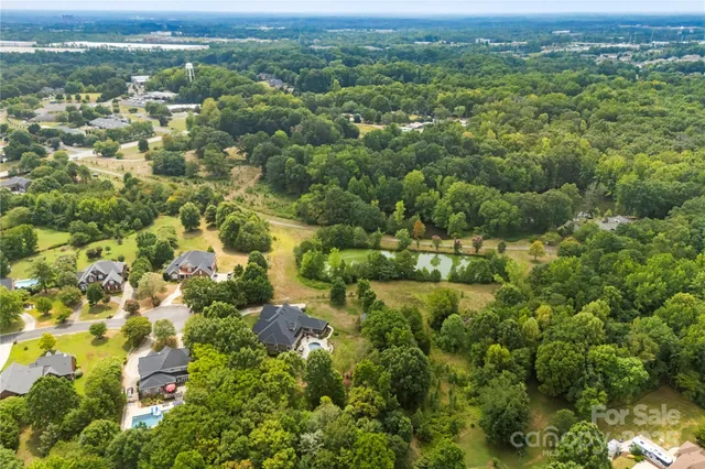 an aerial view of residential houses with outdoor space and trees