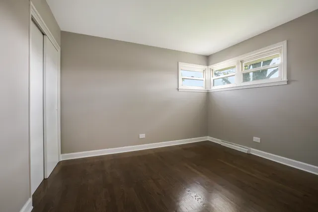a view of a room with wooden floor and windows
