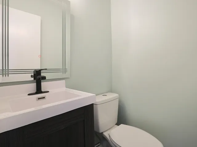 a bathroom with a sink a toilet and a mirror