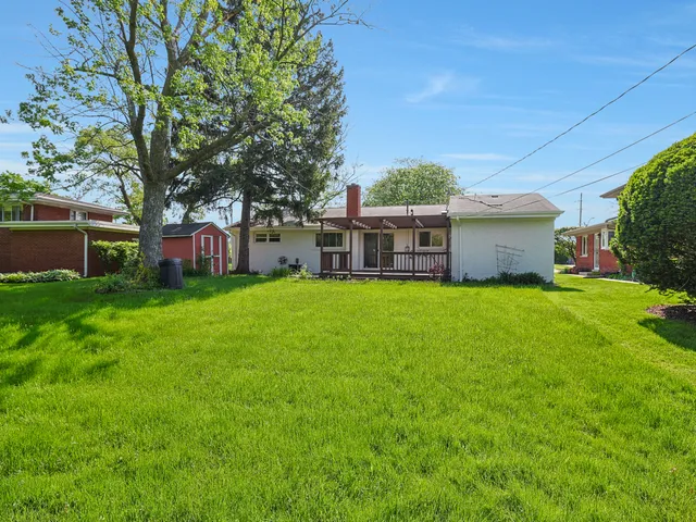 a view of a house with a big yard and large trees