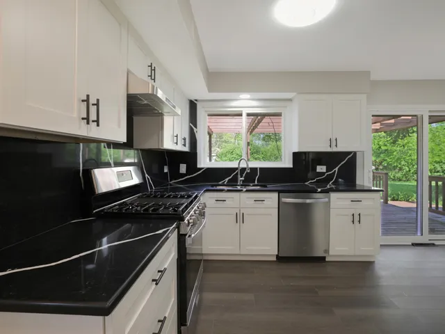 a kitchen with stainless steel appliances a stove sink microwave and cabinets