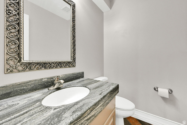 4792 Glasmann Way South Ogden, UT 84403 - Photo 48 of 70 Main floor 1/2 bath with vanity featuring a patterned stone countertop with an integrated oval sink and brushed nickel faucet