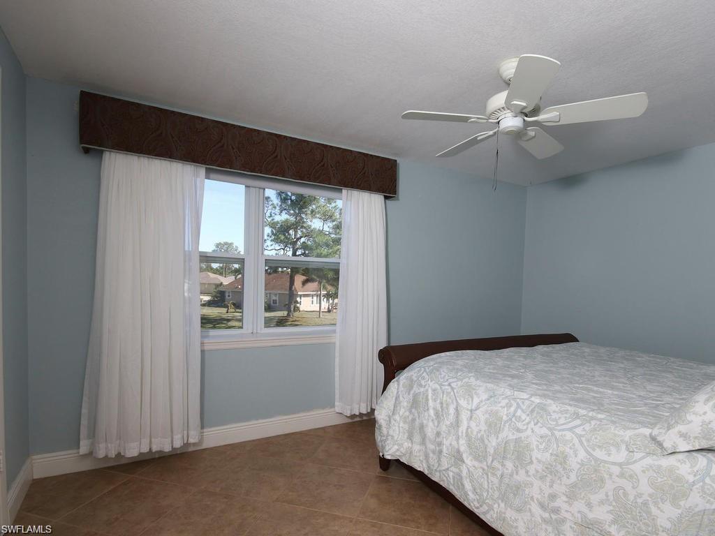 4912 Hawaii Boulevard Naples, FL 34112 - Photo 6 of 12 a bedroom with a bed and a window