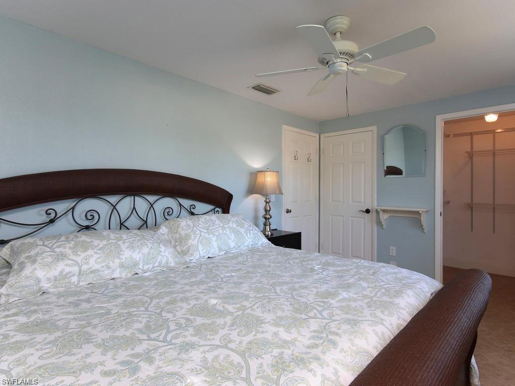 4912 Hawaii Boulevard Naples, FL 34112 - Photo 7 of 12 a bedroom with a bed and a chandelier