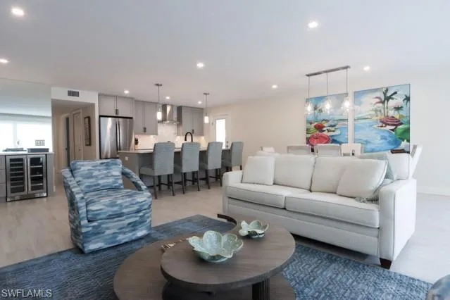 a living room with furniture kitchen and a chandelier