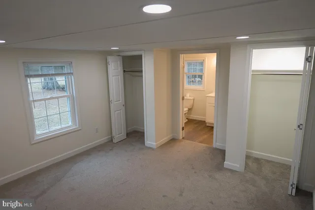 an empty room with windows and closet