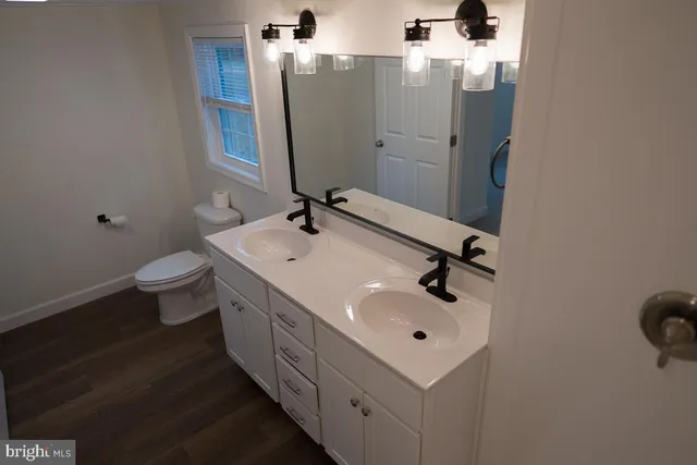 a bathroom with a sink mirror and toilet