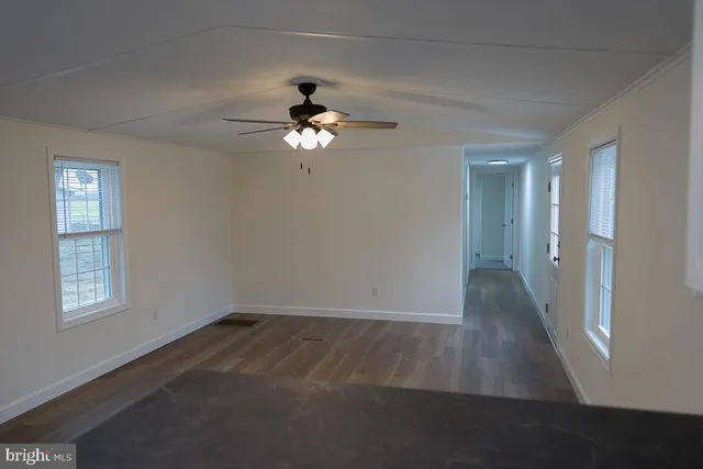 a view of empty room with wooden floor
