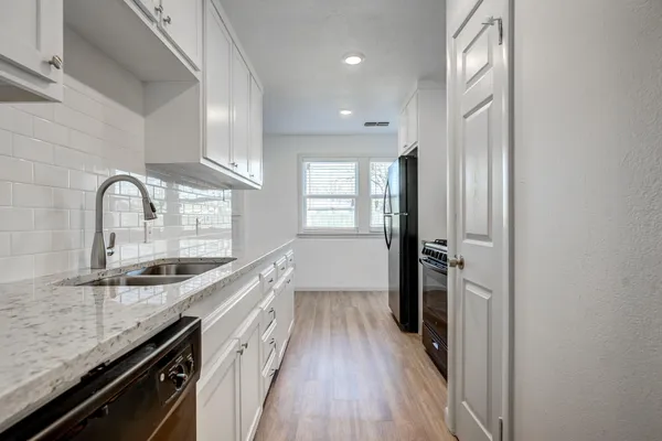 a view of a kitchen cabinets a sink and wooden floor