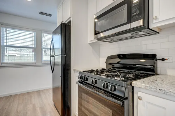 a kitchen with wooden floor and stainless steel appliances