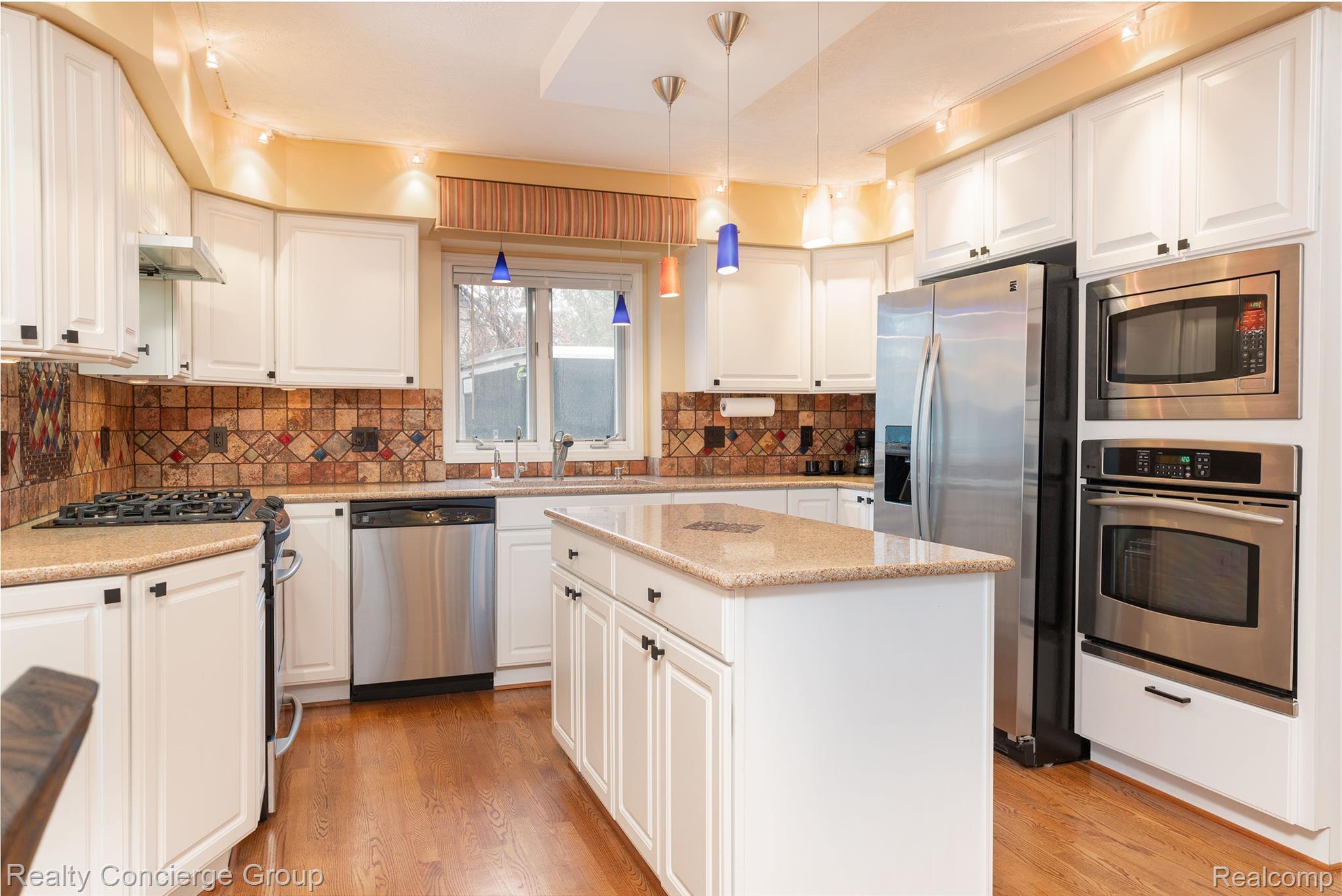 9514 Quail Ridge Run Brighton, MI 48114 - Photo 16 of 37 Kitchen w/granite counter, white cabinets, SS appl