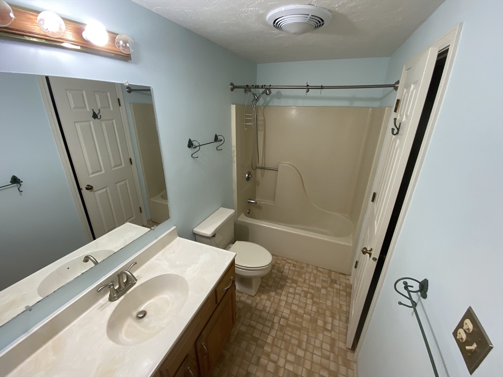 501 Ridgefield Circle, Unit B Clinton, MA 01510 - Photo 16 of 17 a bathroom with a sink a toilet and shower