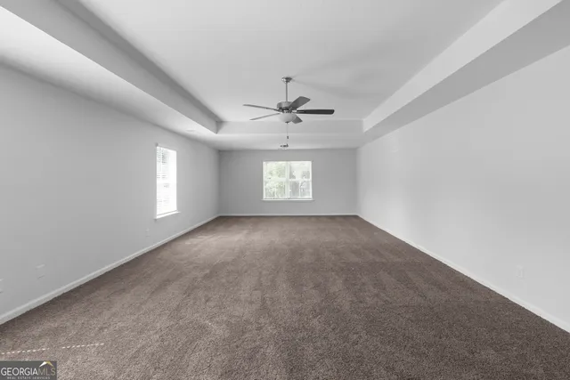an empty room with a window and a ceiling fan