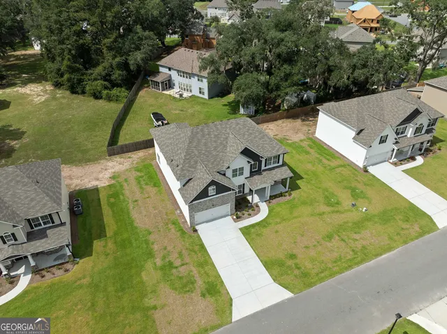 an aerial view of a house with swimming pool and large trees