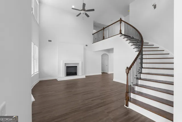 a view of a livingroom with wooden floor and a ceiling fan