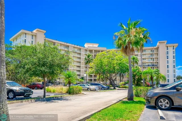 a view of a street with cars and trees