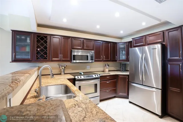 a kitchen with stainless steel appliances granite countertop a refrigerator stove microwave and sink