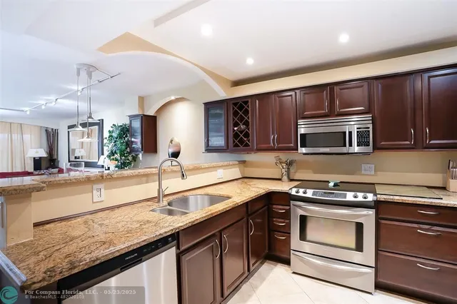 a kitchen with stainless steel appliances granite countertop wooden cabinets stove and microwave