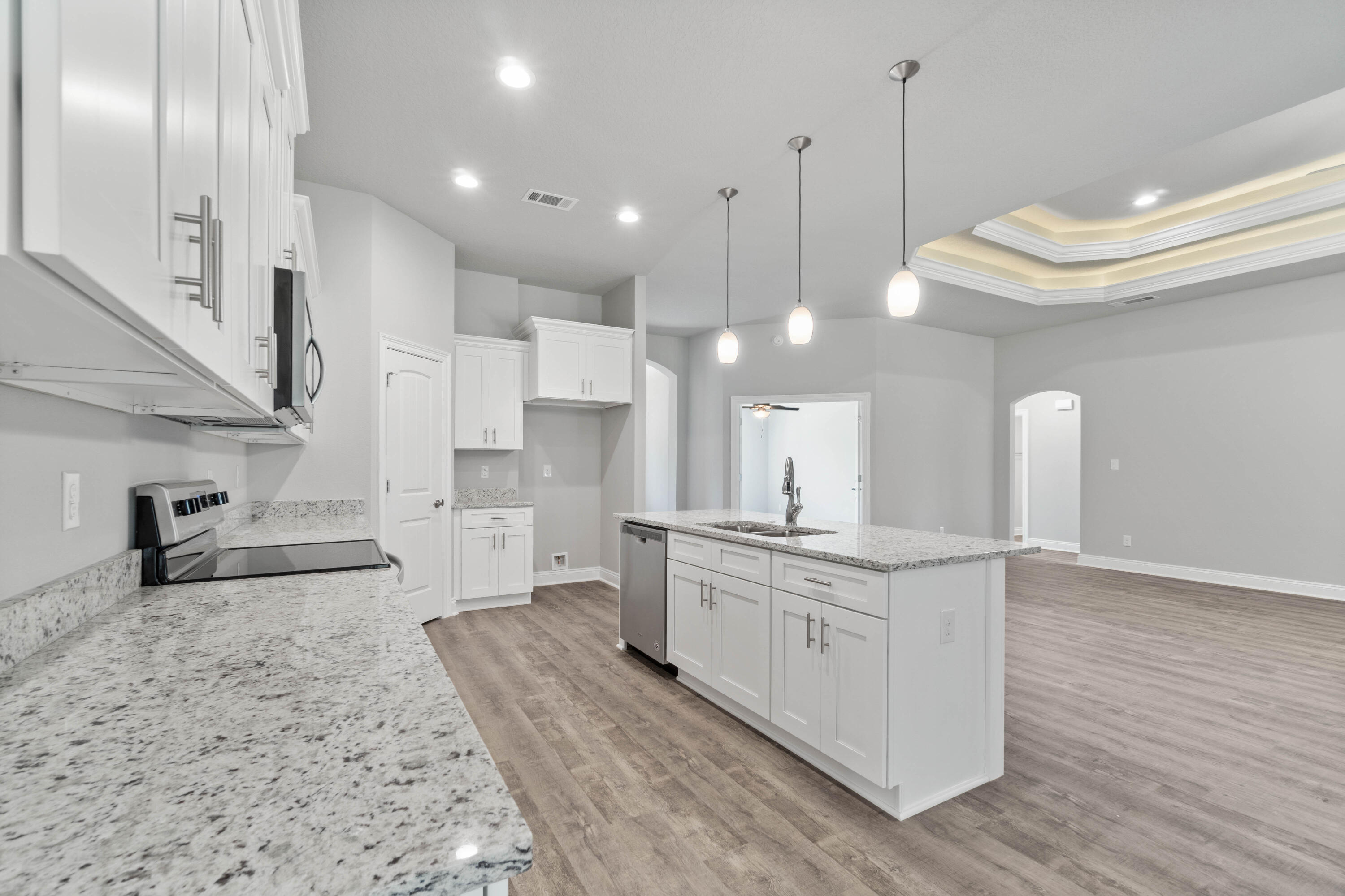 3548 Bob Tolbert Road Navarre, FL 32566 - Photo 14 of 47 a large kitchen with stainless steel appliances kitchen island granite countertop a stove a sink a refrigerator and white cabinets with wooden floor