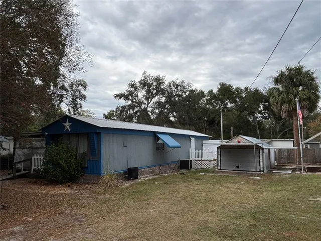 a view of a house with backyard and barbeque area