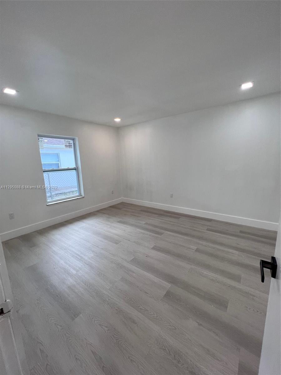 Brownsville Miami, FL 33142 - Photo 14 of 33 an empty room with wooden floor and windows