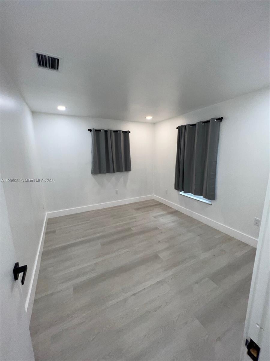 Brownsville Miami, FL 33142 - Photo 16 of 33 a view of an empty room with wooden floor and a window