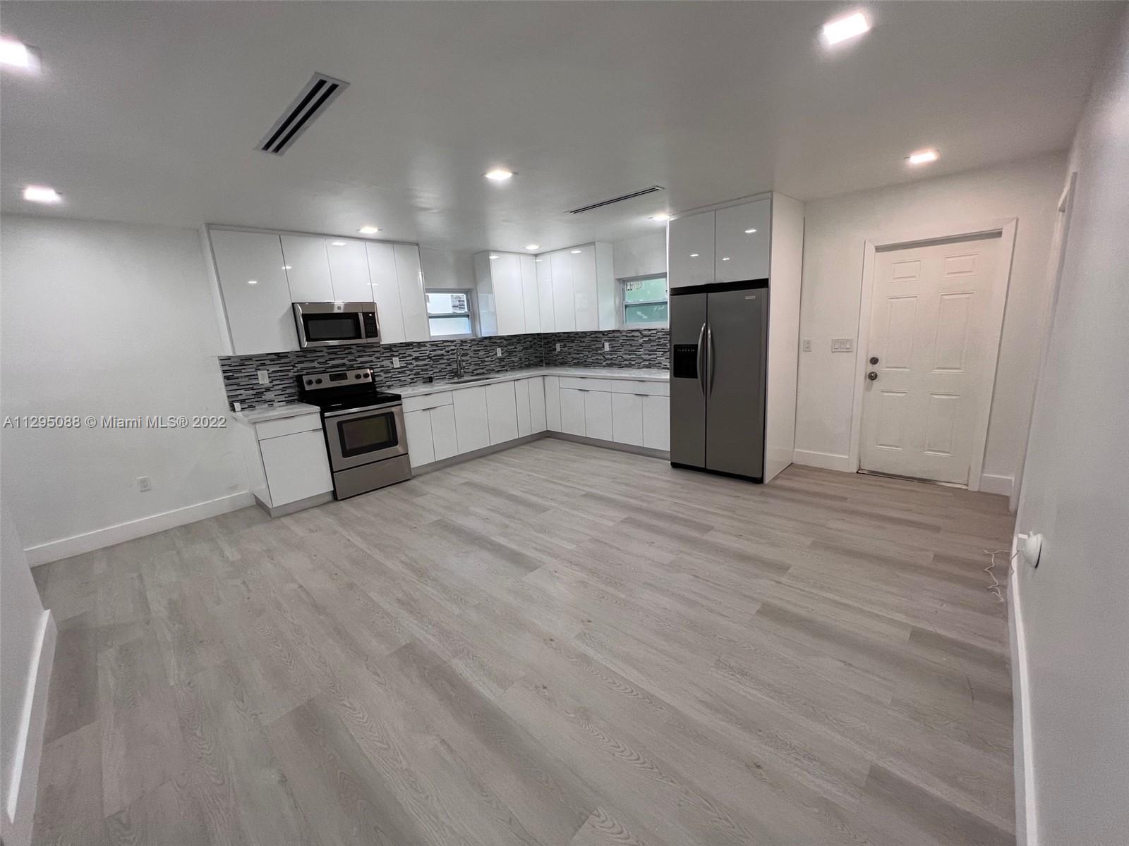 Brownsville Miami, FL 33142 - Photo 19 of 33 a kitchen with stainless steel appliances granite countertop a stove and a refrigerator