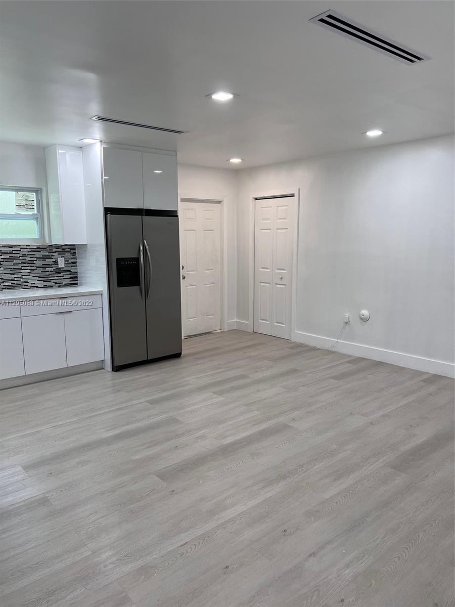 Brownsville Miami, FL 33142 - Photo 5 of 33 an empty room with kitchen appliances and wooden floor
