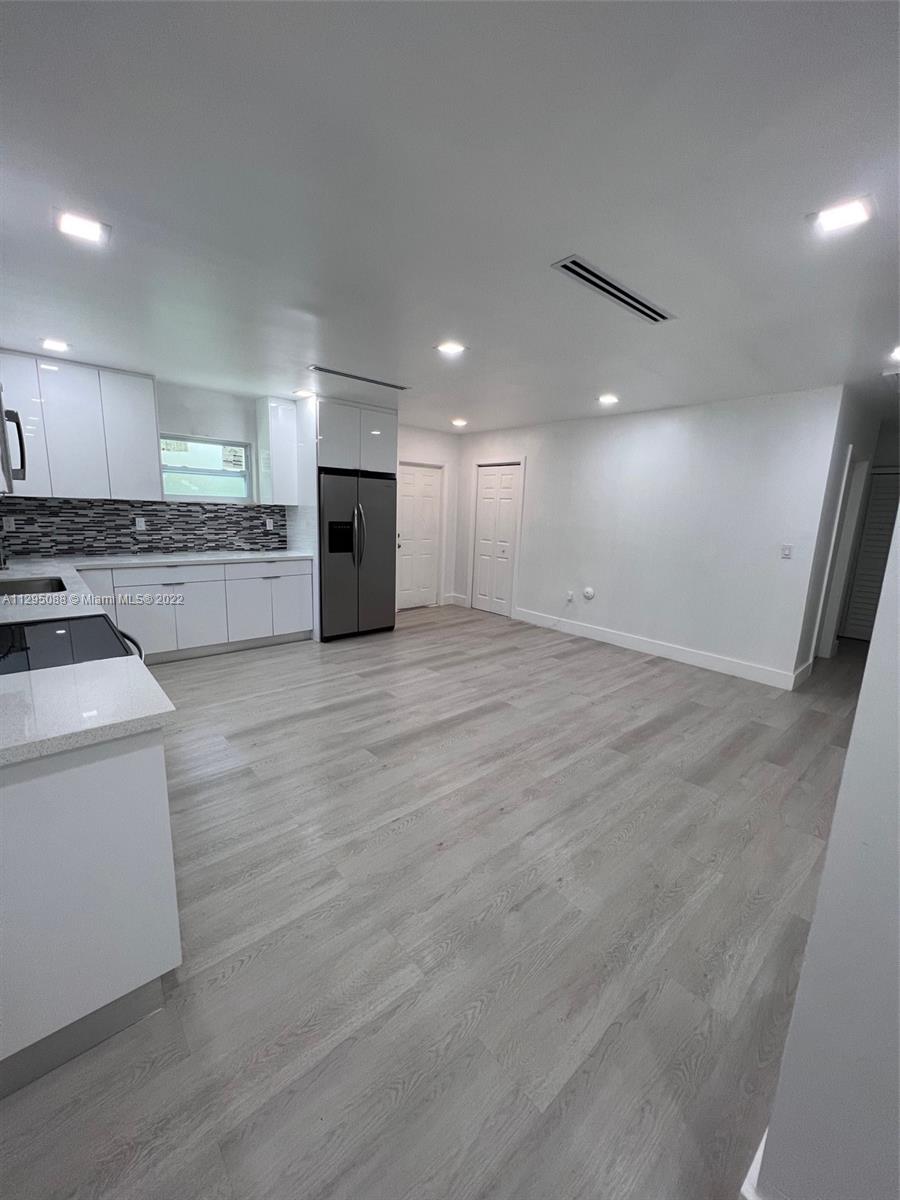 Brownsville Miami, FL 33142 - Photo 6 of 33 an empty room with wooden floor and kitchen view