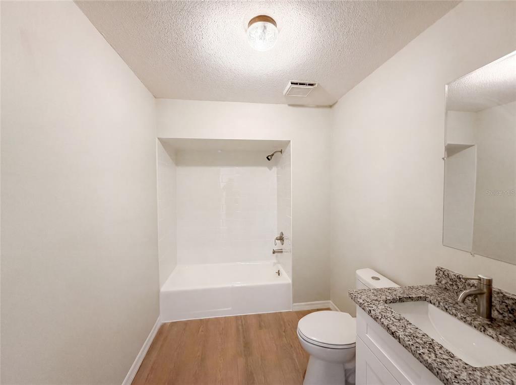 3739 Lake Griffin Road Lady Lake, FL 32159 - Photo 20 of 21 a bathroom with a granite countertop sink a toilet and shower